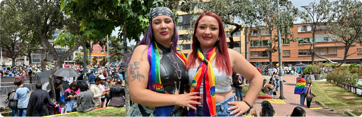 Dos personas con accesorios de los colores del arcoíris participan en un encuentro de los sectores LGBTI en Bogotá.
