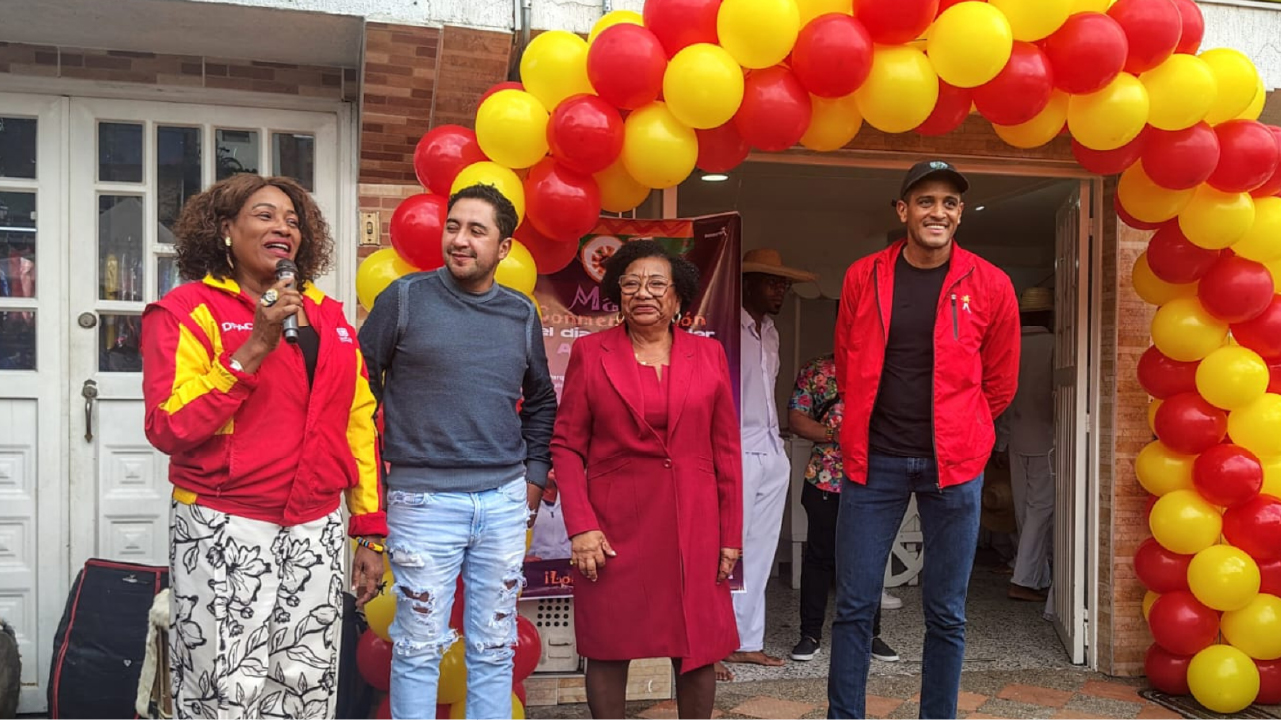 Personas participan en la inauguración de la Casa Afro Las Polonias en Ciudad Bolívar, frente a la sede decorada con globos rojos y amarillos en Bogotá