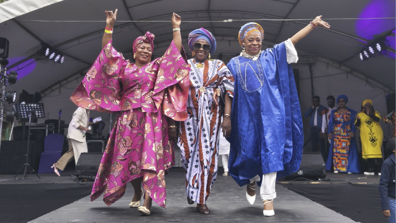 Mujeres afrocolombianas desfilan con trajes tradicionales durante la conmemoración del Día Distrital de las Mujeres Negras Afrocolombianas, evento del IDPAC en Bogotá.