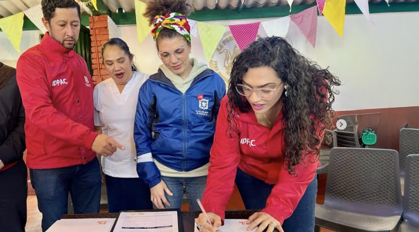Funcionaria del IDPAC firma acuerdo junto a ciudadanía y representantes institucionales durante jornada de participación y convivencia en Bogotá.