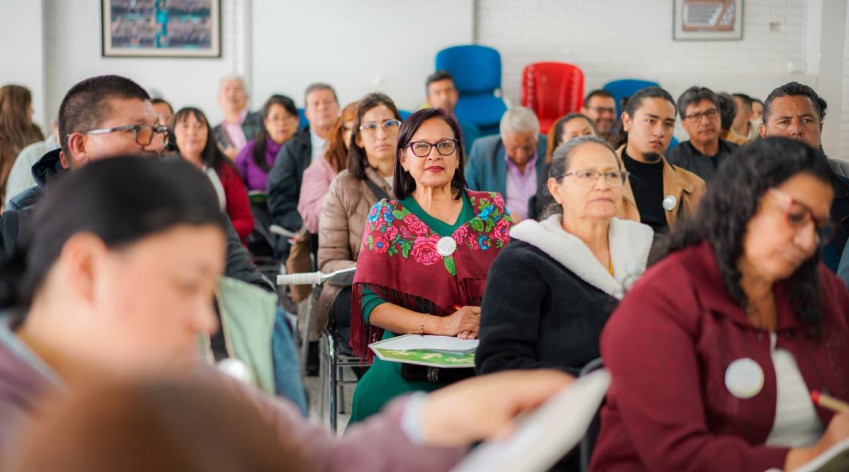 Mujer joven votando frente a urna digital, sobre fondo institucional del IDPAC y Secretaría de la Mujer. Texto: Elecciones Consejo Consultivo de Mujeres 2025–2028. Inscríbete como candidata o votante en www.sdmujer.gov.co hasta el 10 de octubre.