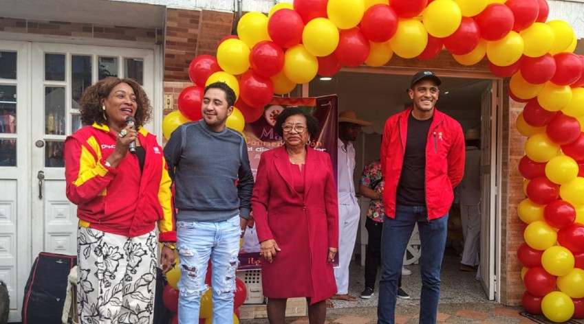 Personas participan en la inauguración de la Casa Afro Las Polonias en Ciudad Bolívar, frente a la sede decorada con globos rojos y amarillos en Bogotá